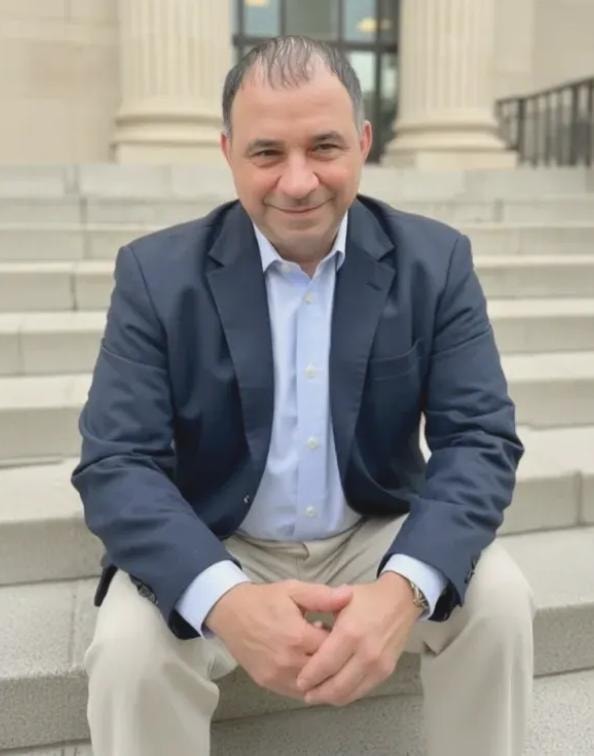 Sammy Aliferis, Immigration Attorney — seated on courthouse steps